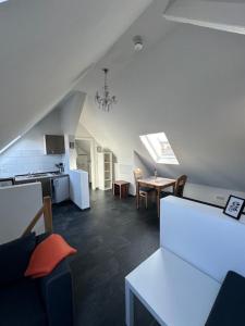 an attic room with a kitchen and a table at Ferienwohnung Fenja in Bonerath