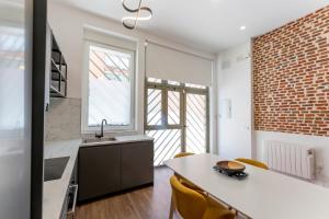 a kitchen with a sink and a table with chairs at Luxe Apartment Madrid North in Madrid