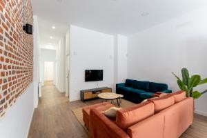 a living room with a couch and a tv at Luxe Apartment Madrid North in Madrid