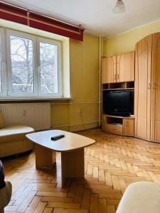 a living room with a table and a tv at Provence style apartment in Košice
