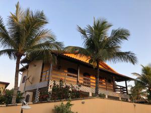 um edifício com palmeiras em frente em Casa Sol e Mar Jaconé: Um paraíso entre o mar e a lagoa em Jaconé