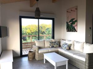a living room with a couch and a table at Mas GEORGES in Saint Alban Auriolles +1 photo
