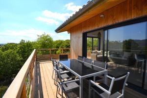 a deck with a table and chairs on a house at Mas GEORGES in Saint Alban Auriolles