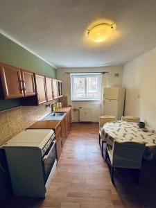 a kitchen with wooden cabinets and a table in it at Provence style apartment in Košice