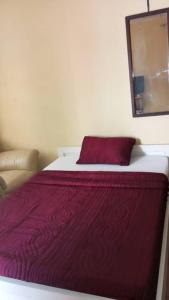 ein Bett mit einer roten Decke darüber in der Unterkunft Julie-Appart in Brazzaville