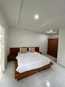 ein Schlafzimmer mit einem großen Bett mit weißer Bettwäsche in der Unterkunft Kusuma Bali House in Ubud