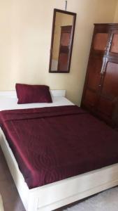Schlafzimmer mit einem Bett mit einer roten Decke und einem Spiegel in der Unterkunft Julie-Appart in Brazzaville