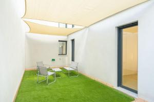 a room with a table and chairs and green carpet at Charming 2 Bedroom Apartment by Torre Del Oro By Oui Sevilla in Seville