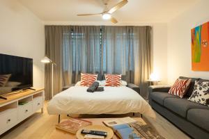 un soggiorno con letto e divano di Charming 2 Bedroom Apartment by Torre Del Oro By Oui Sevilla a Siviglia