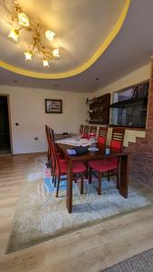 uma sala de jantar com uma mesa de madeira e cadeiras vermelhas em Casa de vis Miriam 