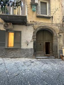 un vecchio edificio con porta e balcone di Casa We Love Napoli a Napoli