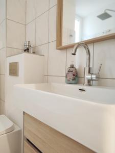 ein weißes Bad mit einem Waschbecken und einem WC in der Unterkunft 'BRIGHT 29' schöne, ruhige Innenstadtlage in Bielefeld, 400 m bis Klinikum Mitte, Smart TV, WLAN in Bielefeld