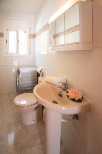 a white bathroom with a toilet and a sink at Chalet individual con piscina privada en Miami Playa in Miami Platja