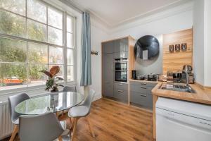 a kitchen with a glass table and some windows at Spacious Two Bedroom Apartment in Camden by London Zoo in London