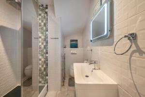 a white bathroom with a sink and a toilet at Spacious Two Bedroom Apartment in Camden by London Zoo in London