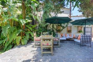 une terrasse avec une table, des chaises et des parasols dans l'établissement La Madrague 3 Bedroom Villa with Garden in Batroun, à Batroun