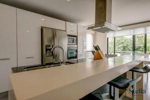 eine Küche mit einer großen weißen Theke und einem Waschbecken in der Unterkunft Golfers' Paradise at Nick Price Residences! in Playa del Carmen