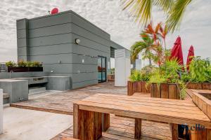 eine Terrasse mit einer Holzbank und einem Gebäude in der Unterkunft Golfers' Paradise at Nick Price Residences! in Playa del Carmen