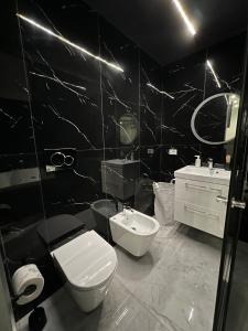 a black and white bathroom with a toilet and a sink at Giufra in Bari