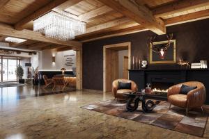 a living room with a fireplace and two chairs at Kesselspitze Valamar Collection Hotel Superior in Obertauern