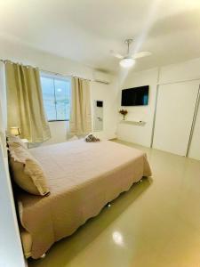 um quarto com uma cama e uma grande janela em Hospedagem Caminho das Praias em Niterói