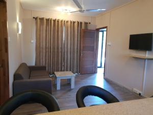 a living room with a couch and a tv at Modern 1 -Bed room Apartment in Grand Baie in Grand Baie