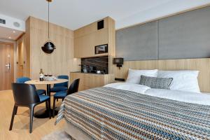 sypialnia z łóżkiem i stołem z krzesłami w obiekcie Deo Apartamenty na Wyspie Spichrzów w Gdańsku