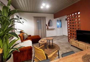 a living room with a couch and a tv at Skapin house in Skopelos Town