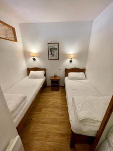 a room with two beds in a room with a table at Les Orres 1800 - 6 places Plein Sud avec Piscine in Les Orres