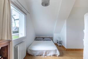 a white bedroom with a bed and a window at Ker Helly - Belle Maison avec Terrasse à Fréhel in Frehel