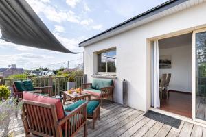 a patio with chairs and a table on a deck at Ker Helly - Belle Maison avec Terrasse à Fréhel in Frehel