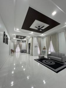 a large living room with a couch and a rug at Homestay Singgah Tamu Al Amin in Bukit Payong