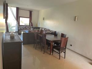 una cucina e una sala da pranzo con tavolo e sedie di Appartement a Marrakech