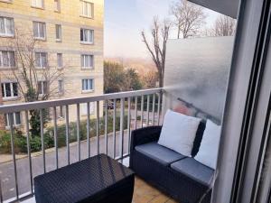 een stoel op een balkon met uitzicht op een gebouw bij Promenons nous dans les Bois in Bougival