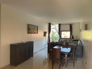 Appartement في مراكش: غرفة طعام مع طاولة وكراسي ومطبخ