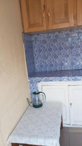 a small kitchen with a counter with blue tiles at Julie-Appart in Brazzaville