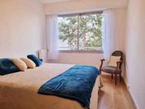 een slaapkamer met een bed, een raam en een stoel bij Promenons nous dans les Bois in Bougival