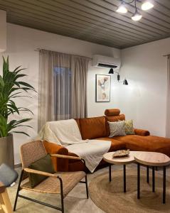 a living room with a brown couch and a table at Skapin house in Skopelos Town