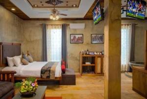 a bedroom with a bed and a tv and a couch at Model Temple Villa in Siem Reap