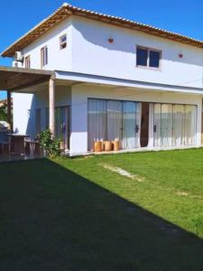 ポルト・セグロにあるCasa nova completa a poucos passos da Praia do Mutàの芝生の白い家
