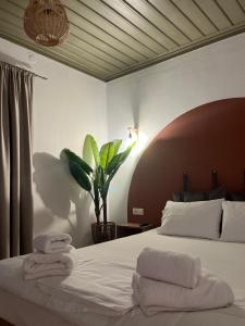 1 dormitorio con 1 cama con toallas en Skapin house, en Skopelos Town