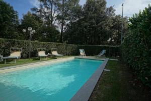 uma piscina com duas espreguiçadeiras em Villa Lilli con piscina riscaldata em Montecatini Terme