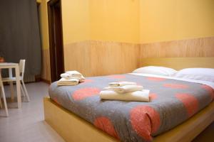 una camera da letto con un letto e asciugamani di On The Rainbow B&B a Roma