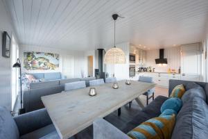 a dining room and living room with a wooden table at Moderne hytte på fantastiske Gimsøy i Lofoten in Gimsøy