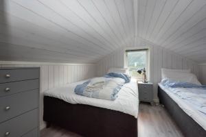 a bedroom with two beds and a window at Moderne hytte på fantastiske Gimsøy i Lofoten in Gimsøy