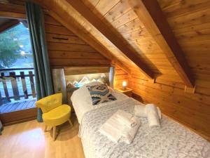 a bedroom with a bed in a wooden house at LE LOUP Chalet en bois in La Bresse
