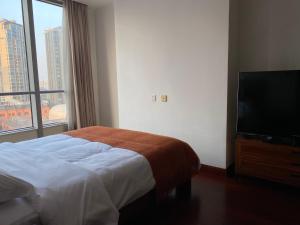a bedroom with a bed and a flat screen tv at River House Near The Peoples Square And The Bund in Shanghai