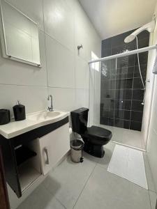 y baño con aseo, lavabo y ducha. en Salles House Maragogi en Maragogi