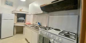 a small kitchen with a stove and a refrigerator at Home 105 Salento in Galatone