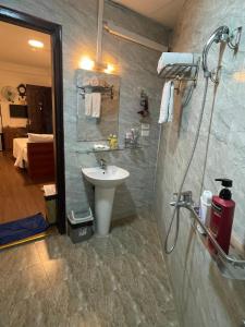 ein Bad mit einem Waschbecken und einer Dusche in der Unterkunft A25 Hotel - Đội Cấn 1 in Hanoi
